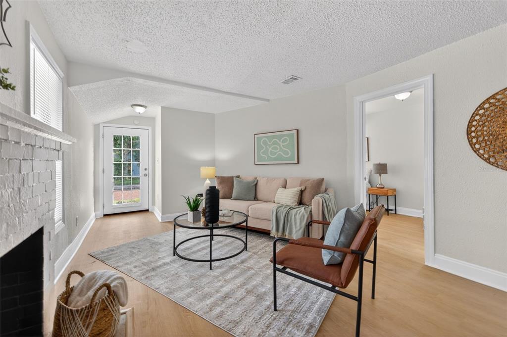 A living room features a beige sofa, a leather armchair, a coffee table, and a fireplace — 1777 28TH AVENUE N, ST PETERSBURG, FL