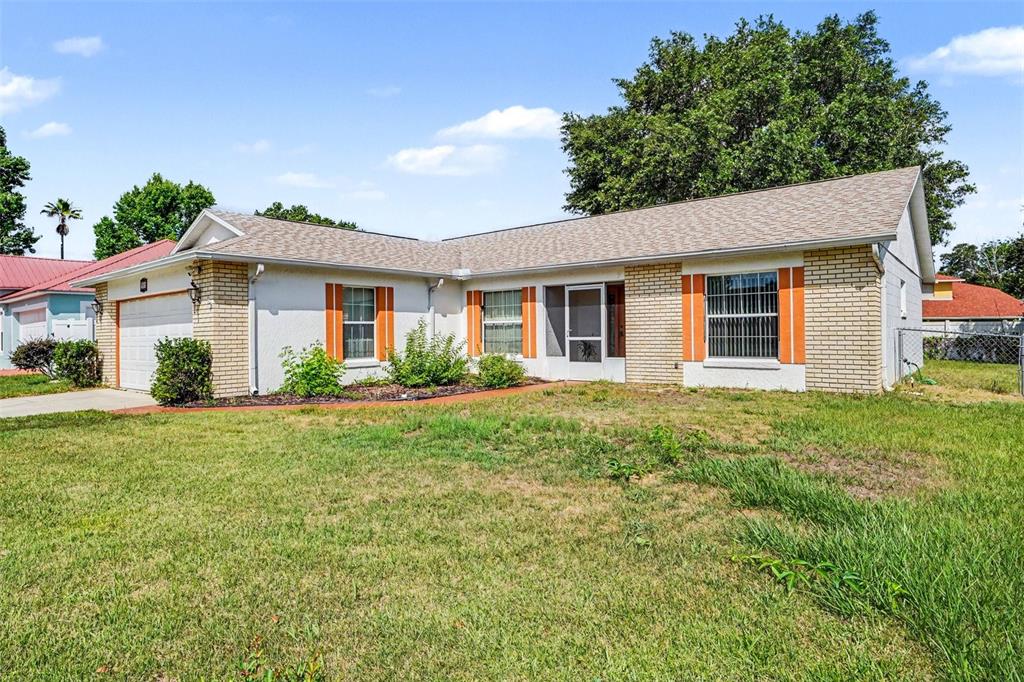A single-story house with a brick and stucco exterior, a garage, and a front lawn — 330 CORTEZ COURT, KISSIMMEE, FL