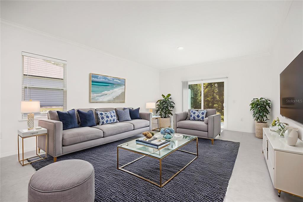A living room features a grey sofa, matching armchair, glass coffee table, and dark rug — 15451 NW 121ST PLACE, ALACHUA, FL