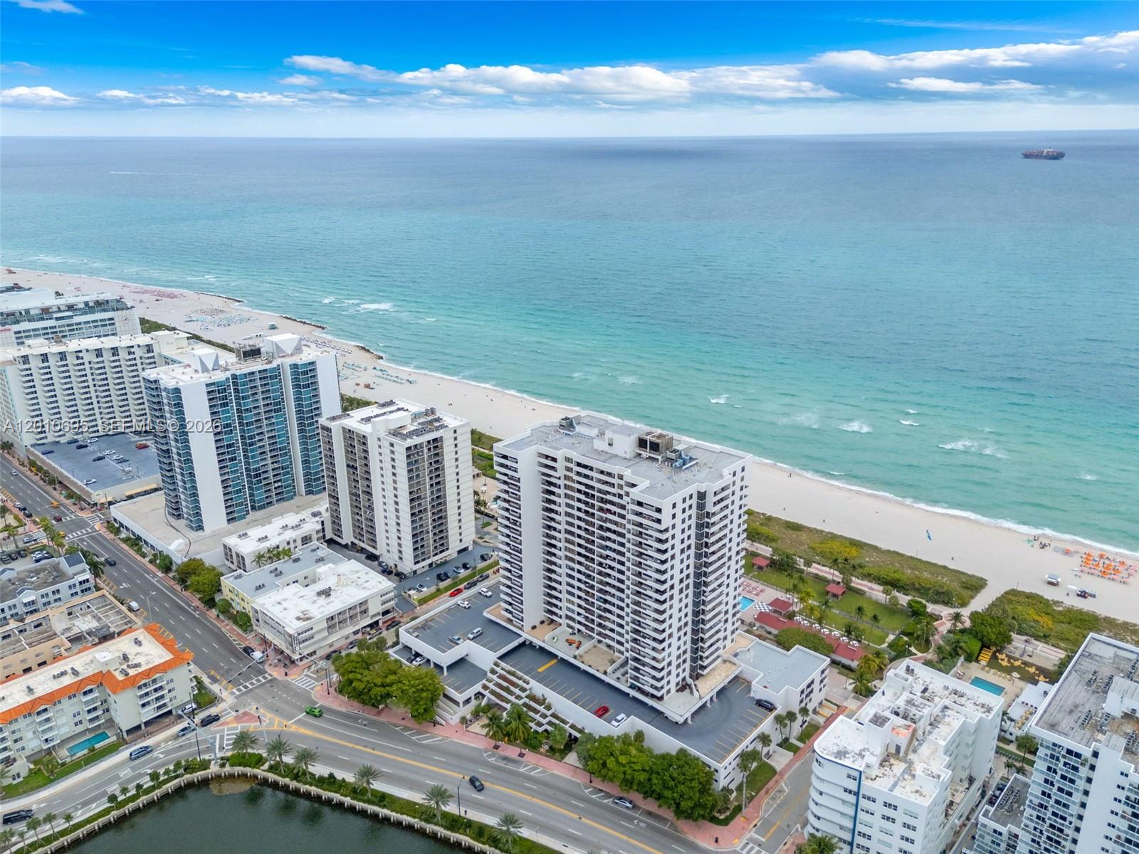 An aerial view shows high-rise apartment buildings situated along a sandy beach and ocean — 2555 Collins Ave # 2401, Miami Beach FL 33140, MIAMI BEACH, FL