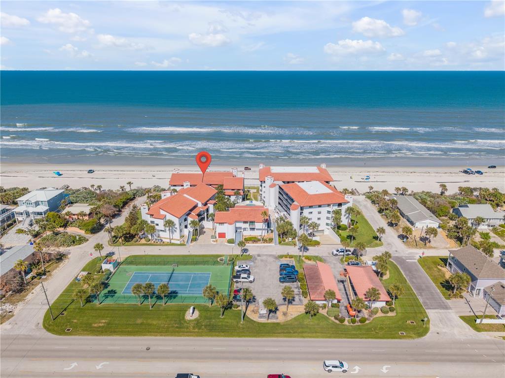 An aerial view of a beachfront condominium complex with a tennis court and parking lot — 3001 S ATLANTIC AVENUE UNIT 305, NEW SMYRNA BEACH, FL