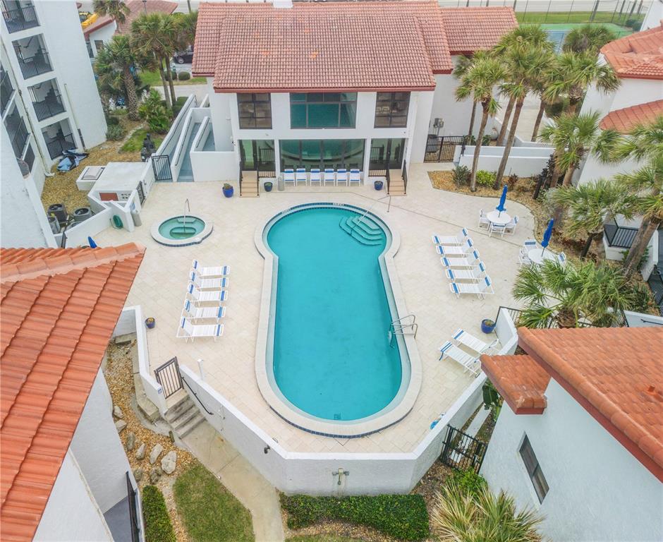 An aerial view of a swimming pool and hot tub surrounded by a paved patio — 3001 S ATLANTIC AVENUE UNIT 305, NEW SMYRNA BEACH, FL