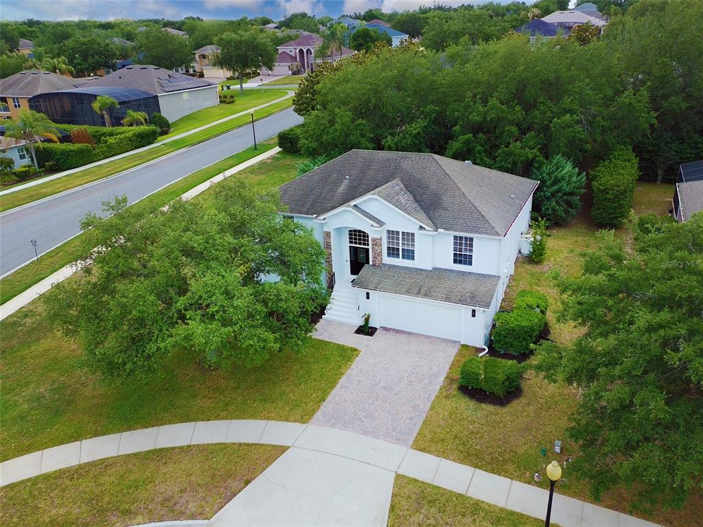 An aerial view of a two-story white house with a paved driveway and green lawn — 1397 LATTIMORE DRIVE, CLERMONT, FL