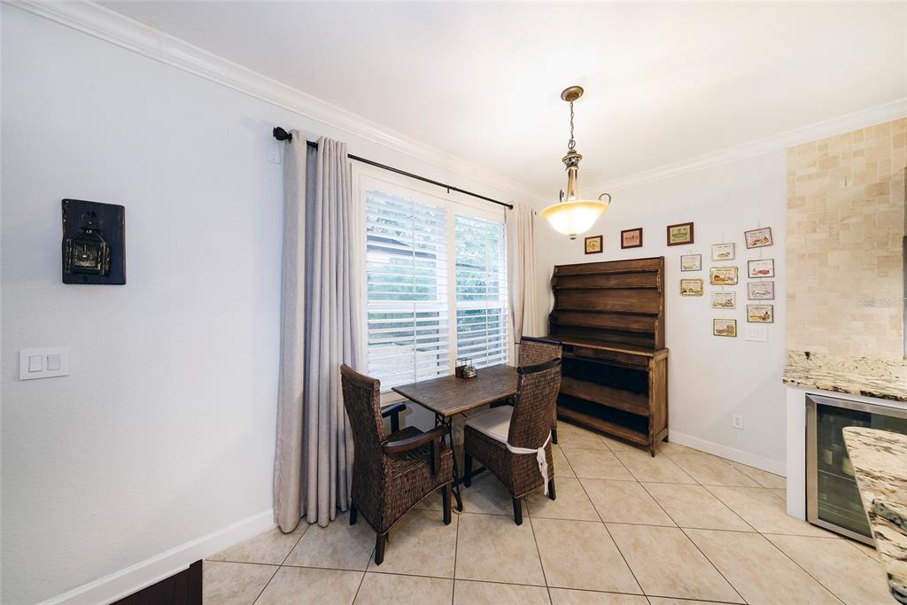 A dining area features a small table, two wicker chairs, a hutch, and tile flooring — 1397 LATTIMORE DRIVE, CLERMONT, FL