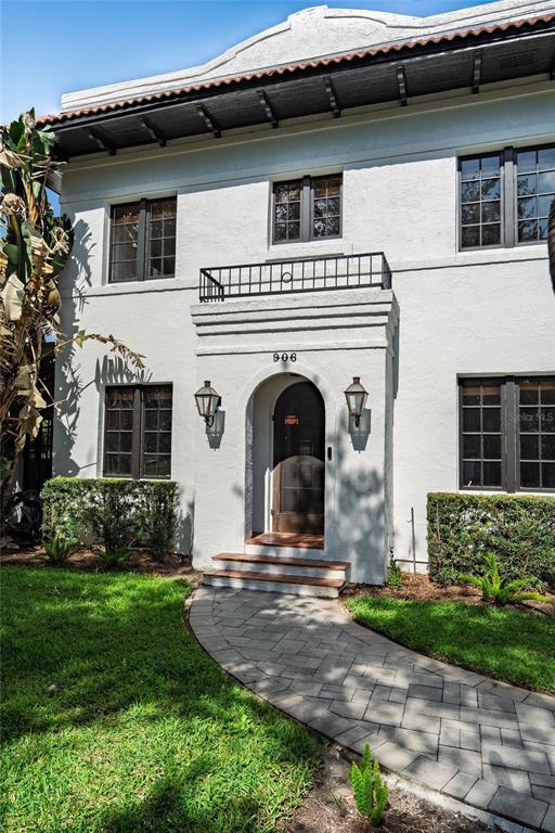 The exterior of a two-story white stucco building features a front entrance with a balcony — 906 ALHAMBRA COURT, ORLANDO, FL
