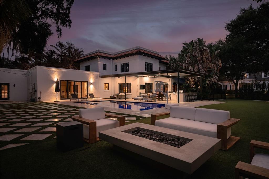 A backyard features a swimming pool, a covered patio, and a fire pit seating area — 906 ALHAMBRA COURT, ORLANDO, FL
