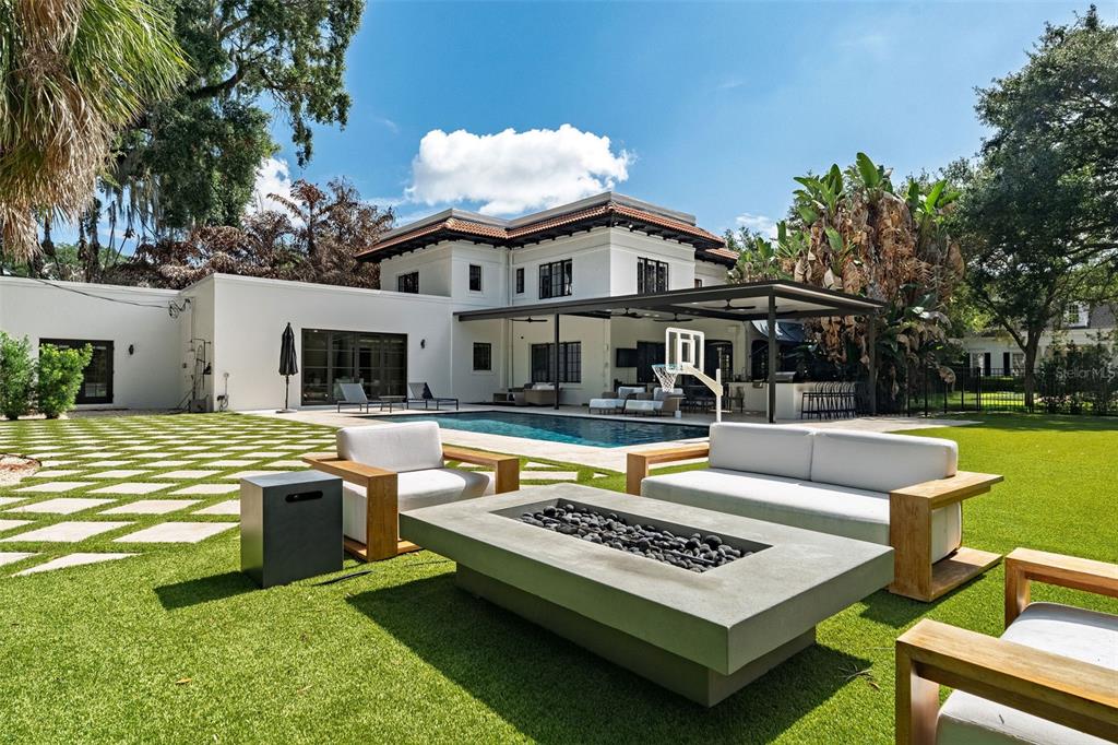 A backyard features a swimming pool, a covered patio, and a fire pit seating area — 906 ALHAMBRA COURT, ORLANDO, FL