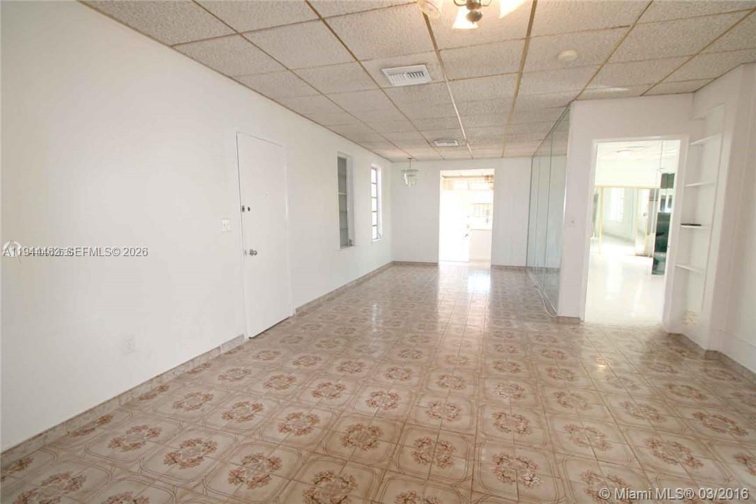 An empty room features light-colored patterned tile flooring, white walls, and a drop ceiling — 1119 SW 9th St, Miami FL 33130, MIAMI, FL