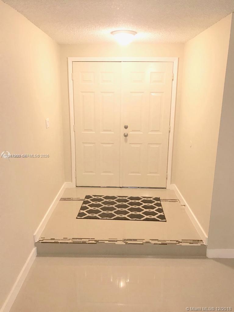 A white double door entry features a tiled floor with a decorative rug — 11447 SW 33rd Ln # 0, Miami FL 33165, MIAMI, FL