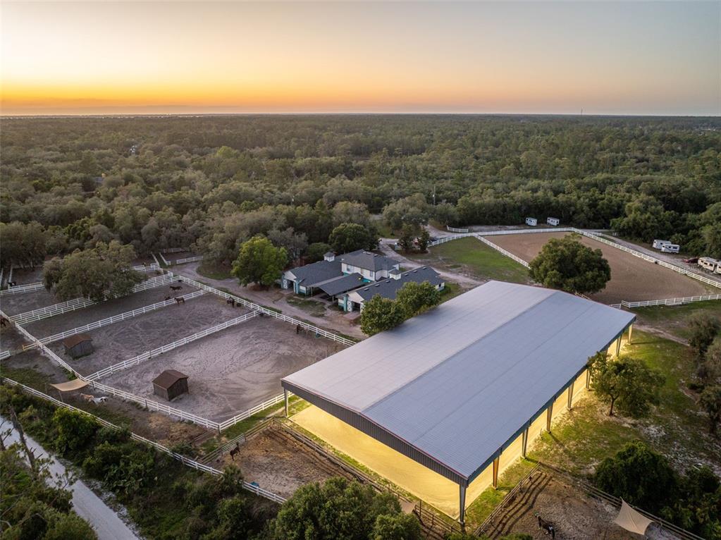 An aerial view shows a horse farm with a large covered arena and fenced paddocks — 3287 N COUNTY ROAD 426, GENEVA, FL