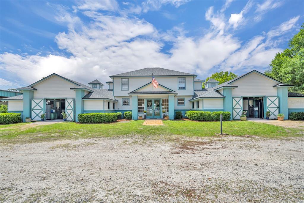 A symmetrical, light-colored barn-style building with a central entrance and two open-bay garage doors — 3287 N COUNTY ROAD 426, GENEVA, FL