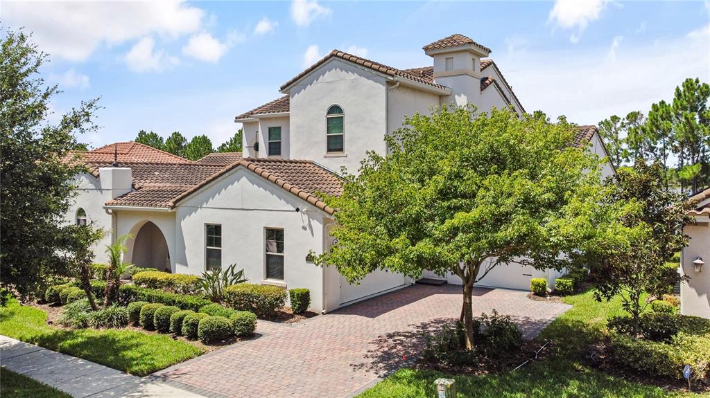 A two-story stucco house with a tiled roof and a brick-paved driveway — 15704 MARINA BAY DRIVE, WINTER GARDEN, FL