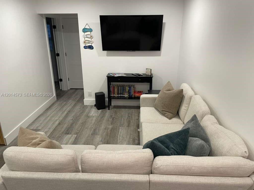 A living room features a sectional sofa, a wall-mounted television, and a console table — 326 Wilson St # 106, Hollywood FL 33019, HOLLYWOOD, FL