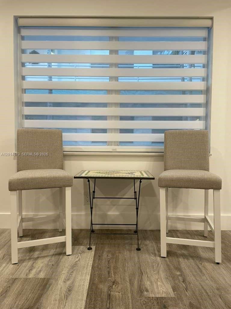 Two upholstered bar stools sit on either side of a small table before a window — 326 Wilson St # 106, Hollywood FL 33019, HOLLYWOOD, FL