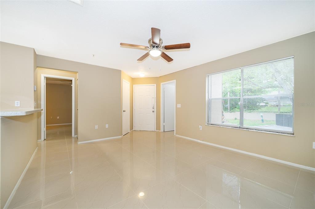 A bright living room features beige walls, light tile flooring, and a ceiling fan — 623 DORY LANE UNIT 204, ALTAMONTE SPRINGS, FL