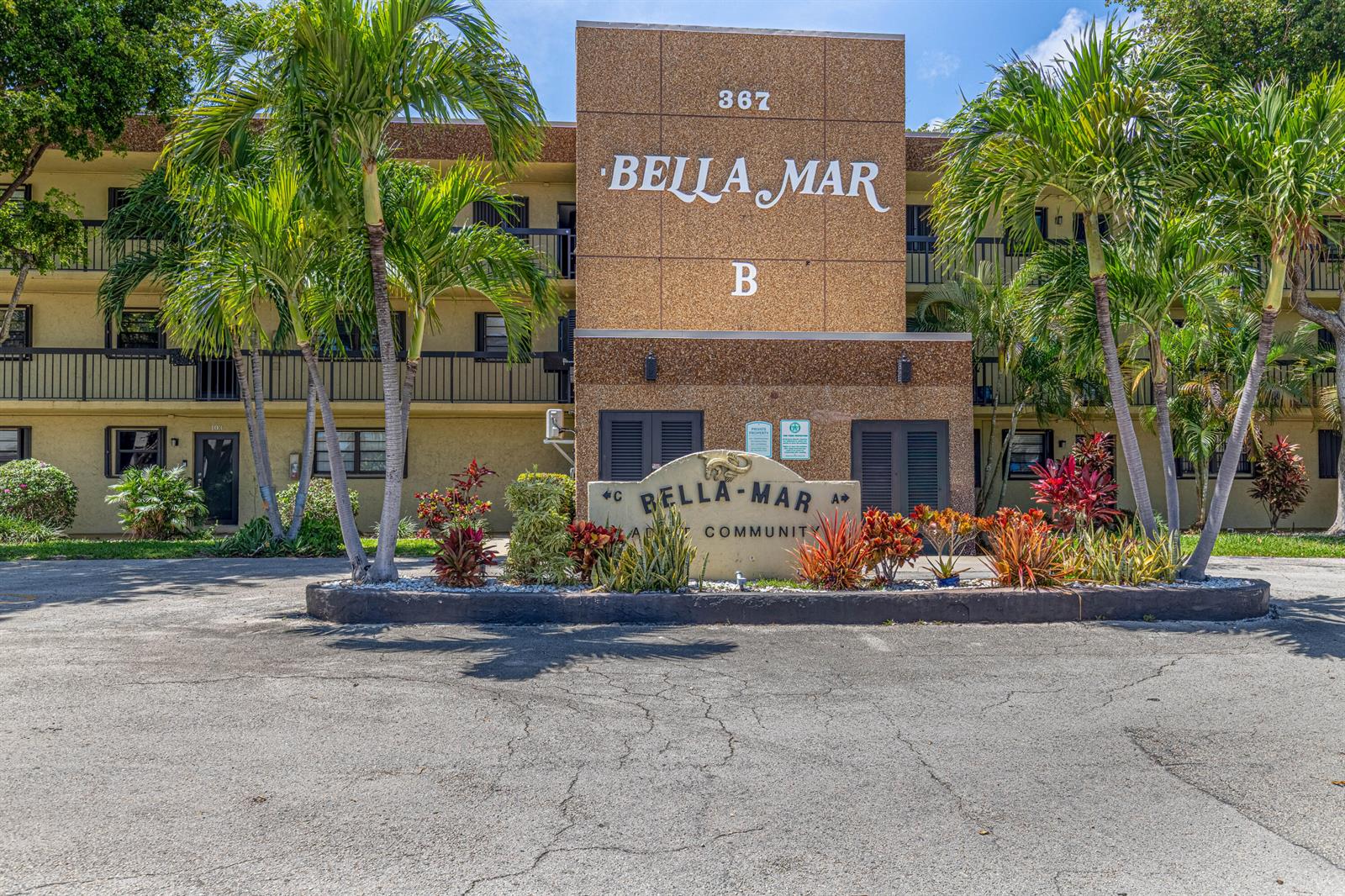 The exterior of a multi-story apartment building features a textured facade and palm trees — 367 S Federal Highway # C323, Deerfield Beach FL 33441, DEERFIELD BEACH, FL
