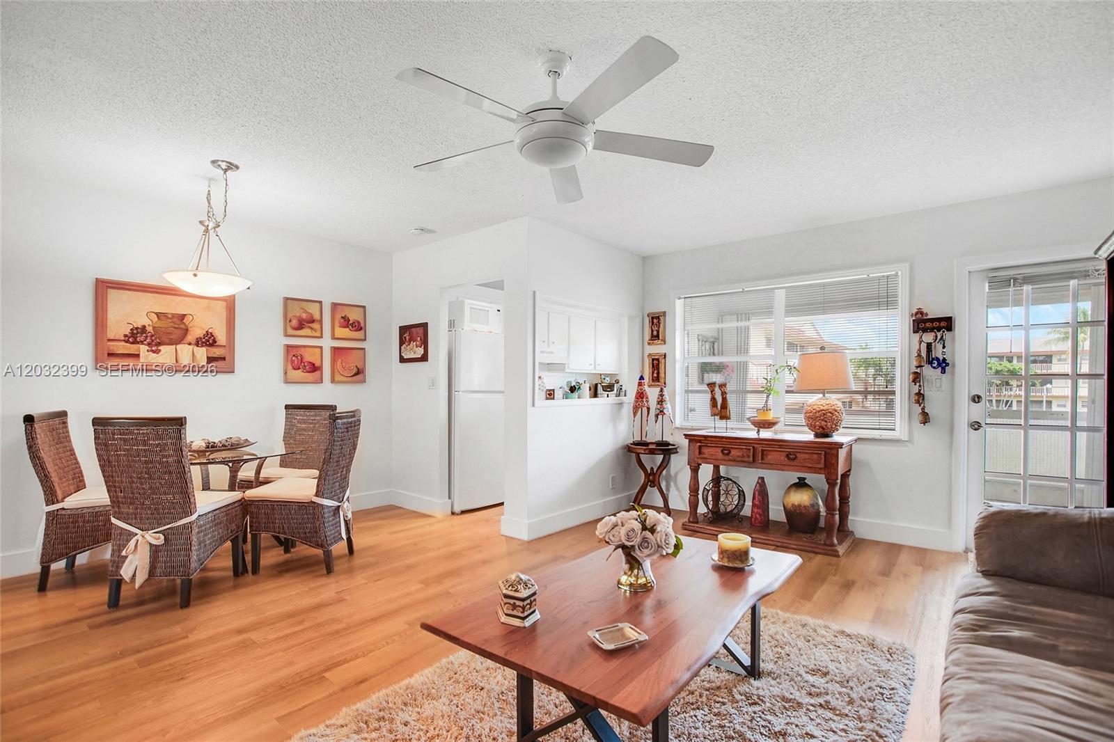 A living and dining area features wood flooring, a ceiling fan, and a wooden coffee table — 5300 Washington St # O224, Hollywood FL 33021, HOLLYWOOD, FL