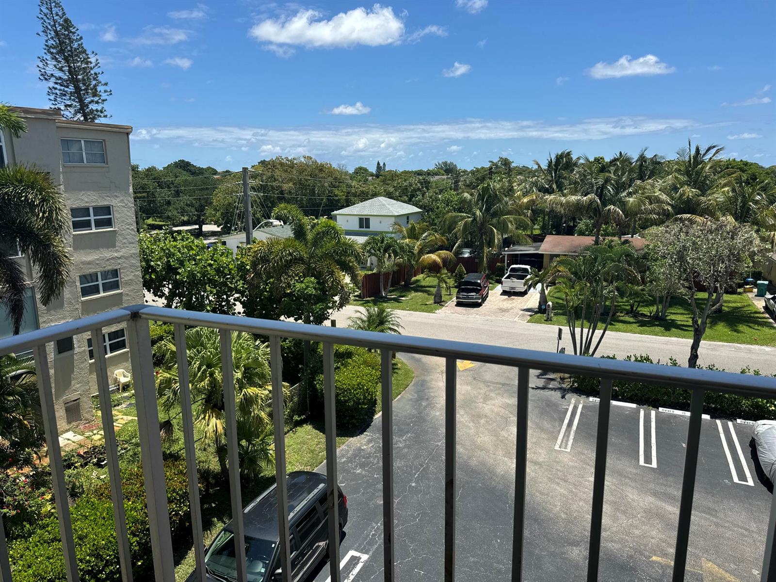 A view from a balcony overlooking a parking lot, palm trees, and residential houses — 2615 NE 3rd Court # 4120, Boynton Beach FL 33435, BOYNTON BEACH, FL