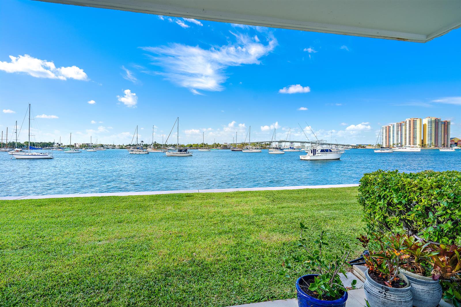A view of a grassy lawn, a harbor with sailboats, and a distant bridge — 1051 Sugar Sands Boulevard # 156, Singer Island FL 33404, SINGER ISLAND, FL