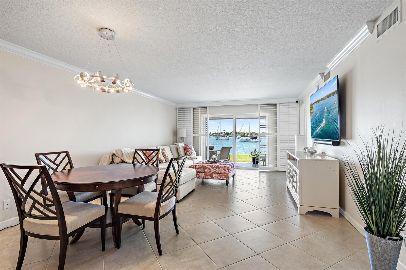 A living and dining area features tile floors, a round table, and a waterfront view — 1051 Sugar Sands Boulevard # 156, Singer Island FL 33404, SINGER ISLAND, FL