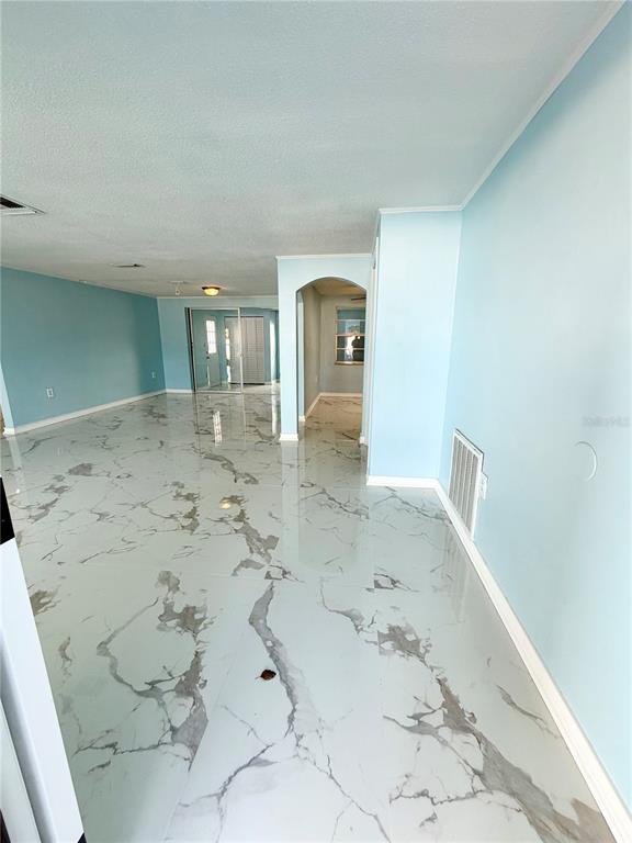 A bright room with light blue walls and white marble-patterned tile flooring — 7040 FOX HOLLOW DRIVE, PORT RICHEY, FL
