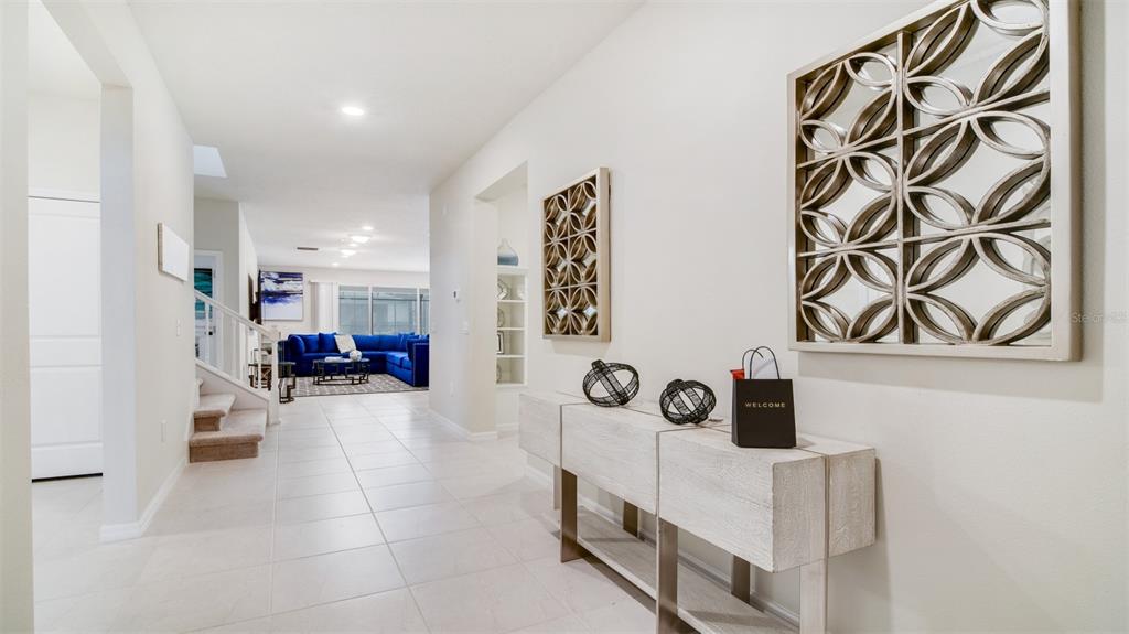 A bright entryway features a console table, wall art, and a view into a living room — 3005 MAHALO DRIVE, DAVENPORT, FL
