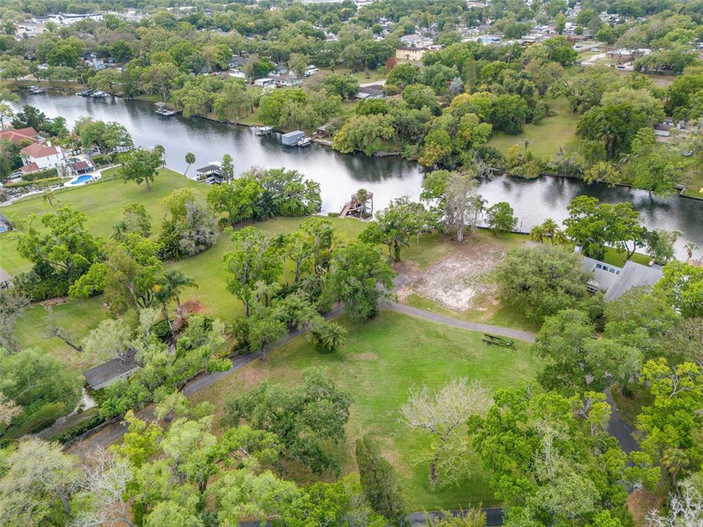 An aerial view shows a grassy property with trees, a driveway, and a riverfront dock — 5924 RIVER TERRACE, TAMPA, FL