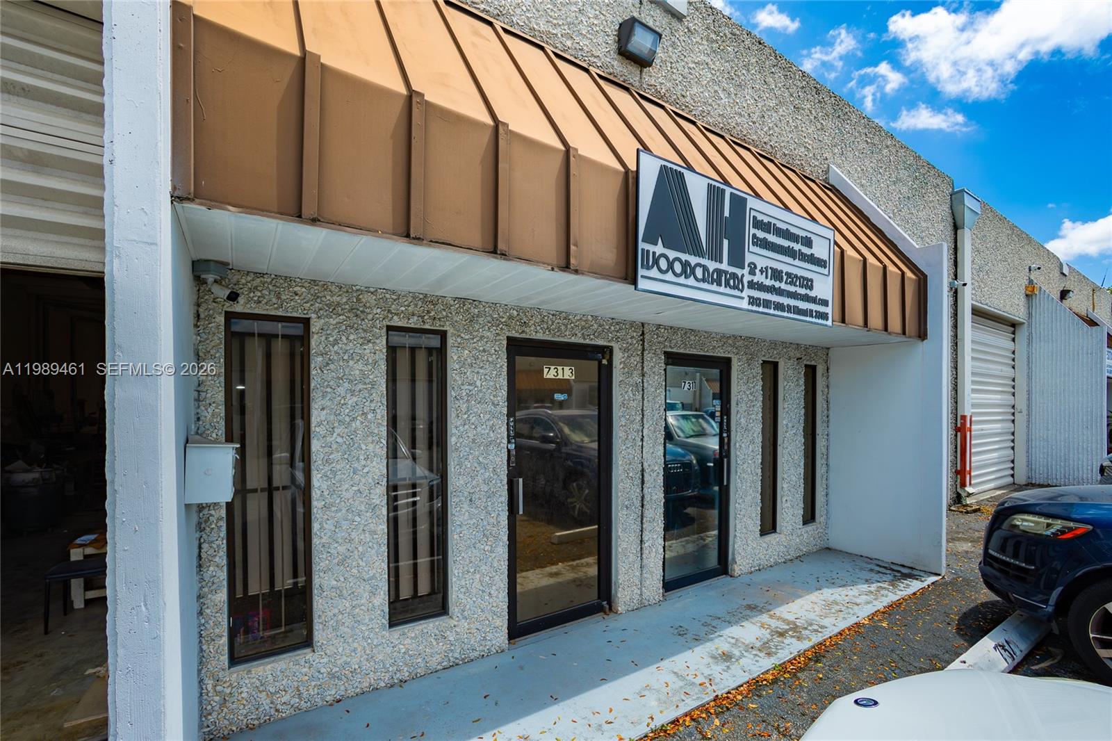 The exterior of a commercial building features a brown metal awning and glass entry doors — 7313 NW 56th St # 7313, Miami FL 33166, MIAMI, FL