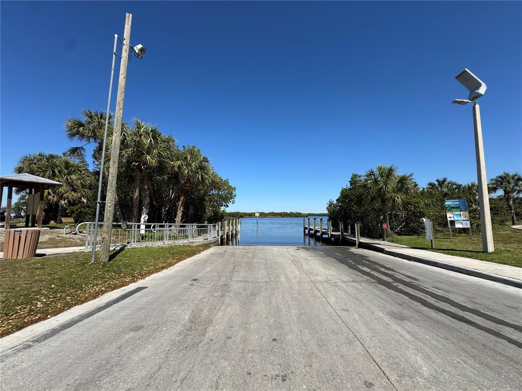 A paved road runs in front of a vacant lot with dense trees and shrubs — 1491 SULSTONE DRIVE, PUNTA GORDA, FL