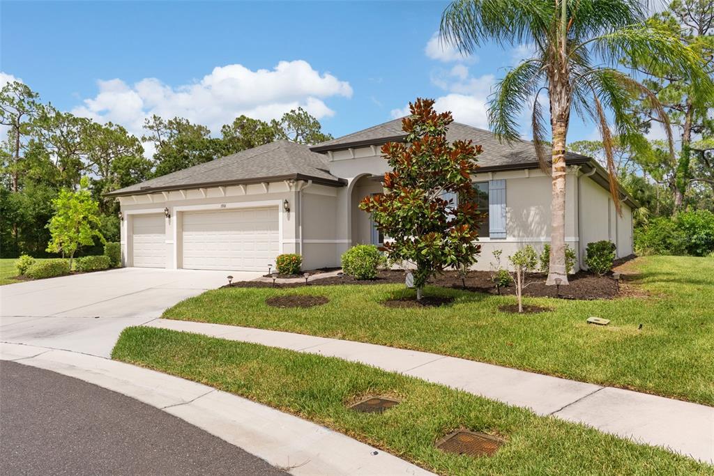 A single-story house with a beige stucco exterior, a three-car garage, and a landscaped yard — 3918 GAVIOTA DRIVE, SUN CITY CENTER, FL