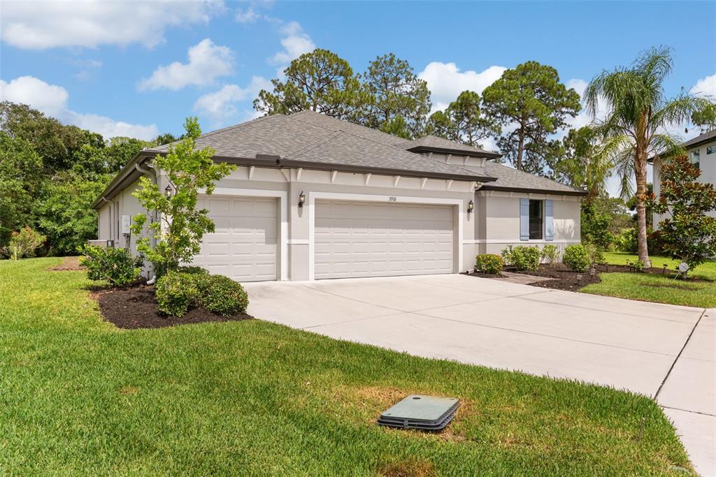 A single-story house with a two-car garage and a concrete driveway on a grassy lot — 3918 GAVIOTA DRIVE, SUN CITY CENTER, FL