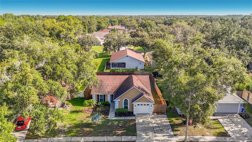 An aerial view of a suburban house with a tan exterior and a red roof — 1032 HARDWOOD DRIVE, VALRICO, FL