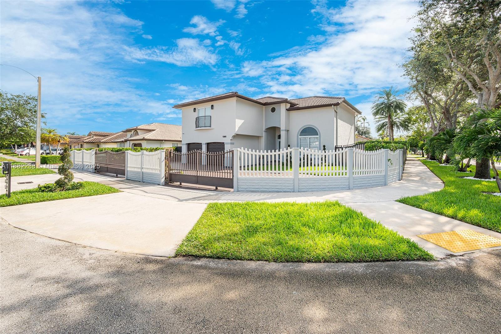A two-story house with a white fence and a gated driveway sits on a corner lot — 1385 SW 143rd Ct, Miami FL 33184, MIAMI, FL