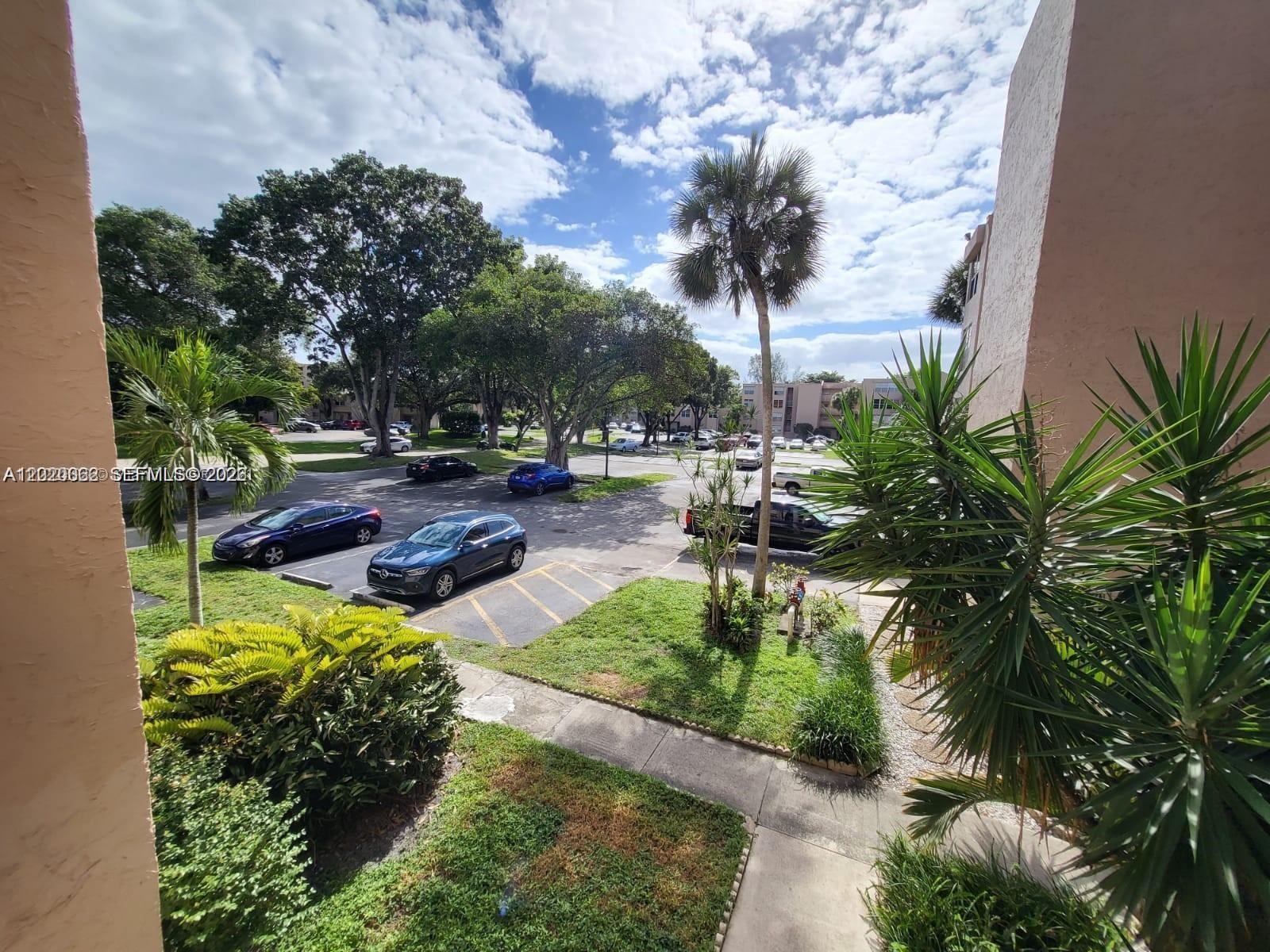 An elevated view of a parking lot surrounded by trees and residential buildings — 9440 Live Oak Pl # 201, Davie FL 33324, DAVIE, FL