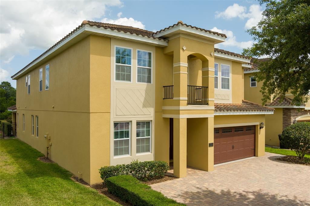 A two-story yellow stucco house with a brown tile roof and a two-car garage — 7519 MARKER AVENUE, KISSIMMEE, FL