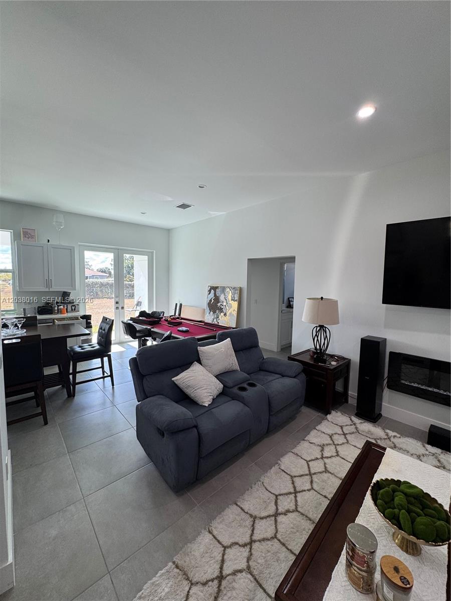 This open-concept living area features a pool table, a gray sofa, and tile flooring — 5012 Gunn PL # 0, La Belle FL 33935, LA BELLE, FL