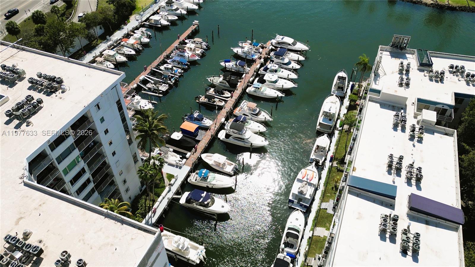 An aerial view shows a marina with numerous boats docked between two large apartment buildings — 1700 NW North River Dr, Miami FL 33125, MIAMI, FL