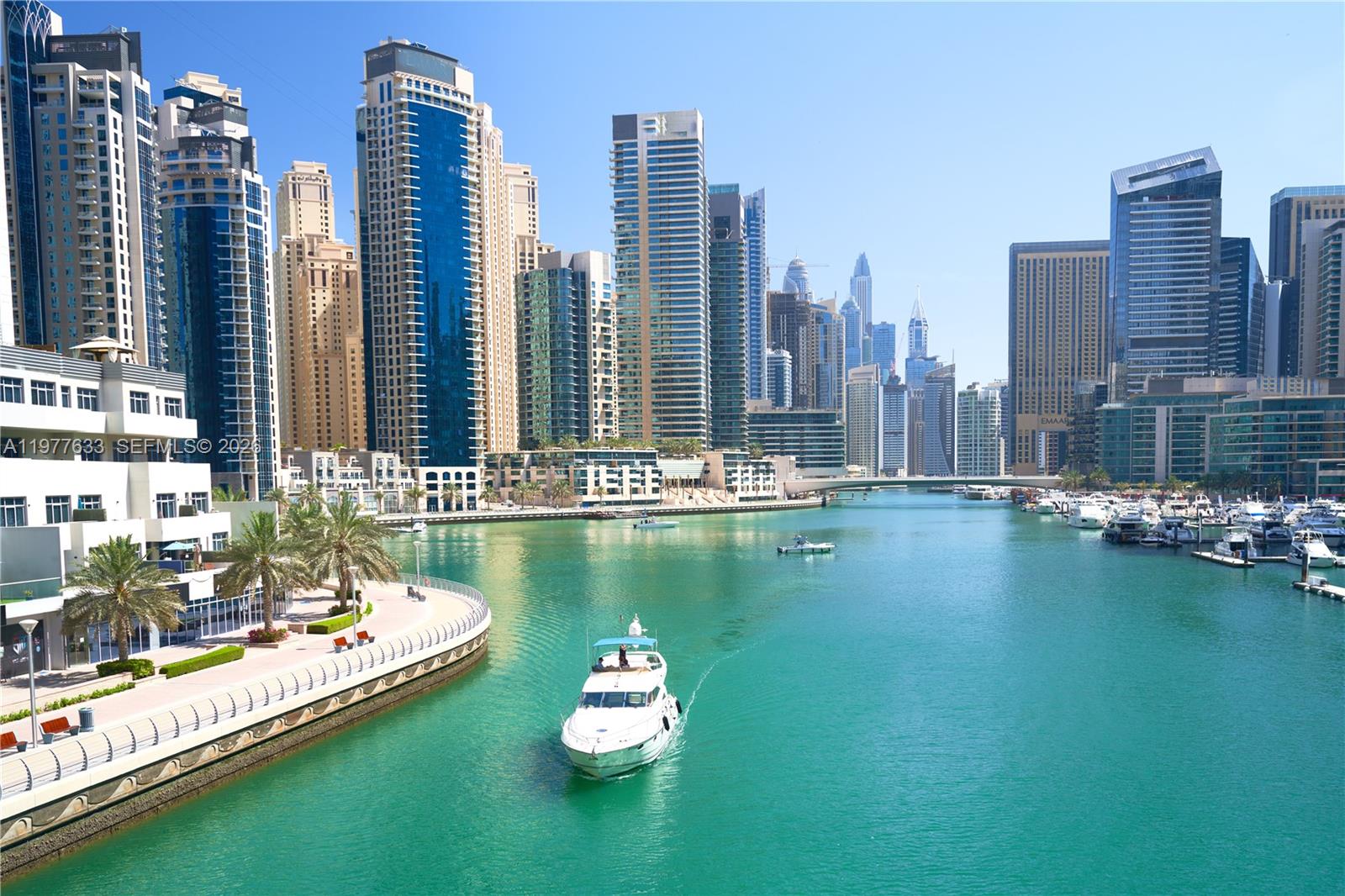 A white yacht travels through the Dubai Marina canal surrounded by numerous modern skyscrapers — 1700 NW North River Dr, Miami FL 33125, MIAMI, FL
