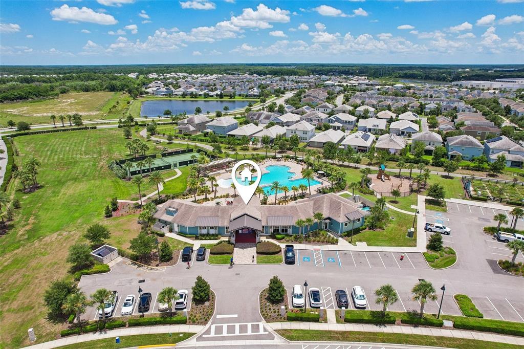 An aerial view shows a community clubhouse with a pool, tennis courts, and parking lot — 11886 FICTION AVENUE, ORLANDO, FL