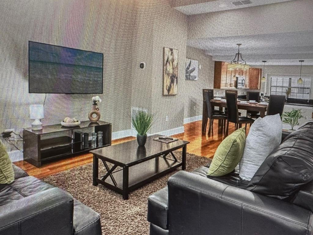 A living room with dark leather furniture, a coffee table, and an open dining area — 14519 DAMAI LANE, ORLANDO, FL