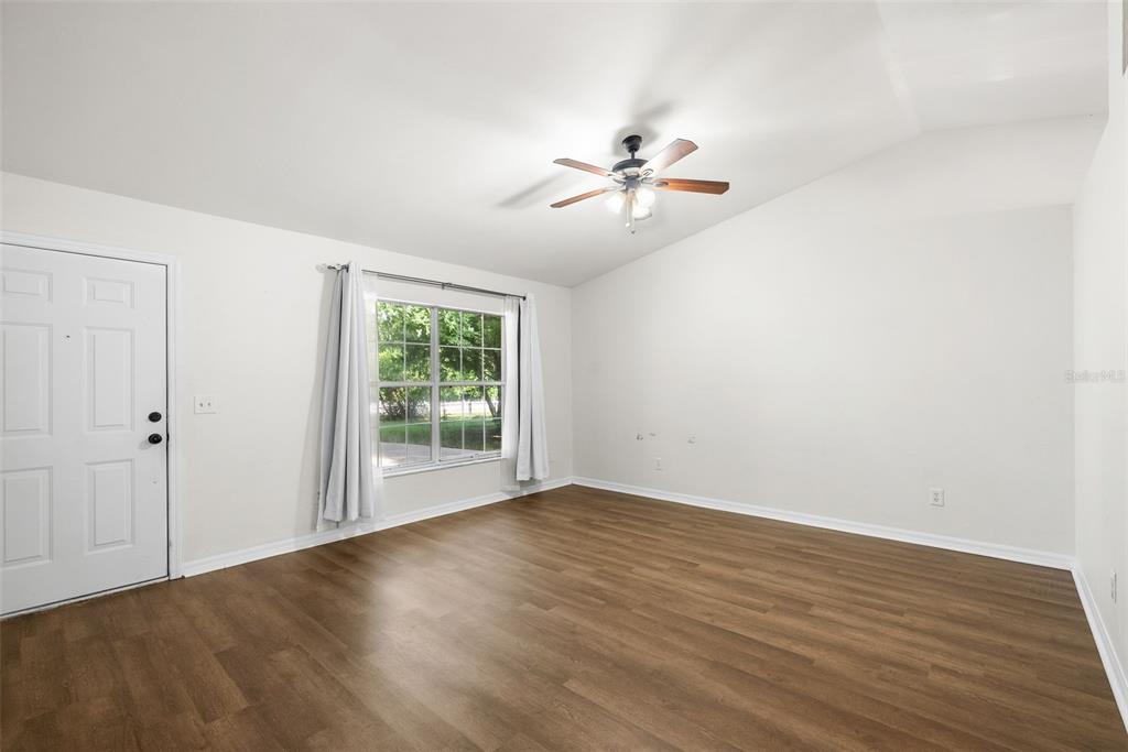 An empty room with white walls, wood-look flooring, a ceiling fan, and a window — 19947 NW 245TH TERRACE, HIGH SPRINGS, FL