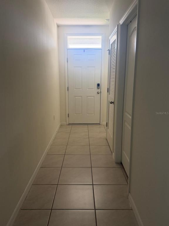 A tiled entryway leads to a white front door with a transom window above — 2439 VIOLET SHELTON COURT, SANFORD, FL