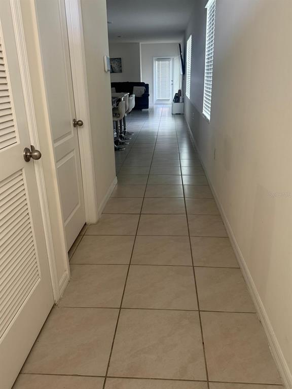 A tiled hallway leads from the foreground toward an open-concept kitchen and living area — 2439 VIOLET SHELTON COURT, SANFORD, FL