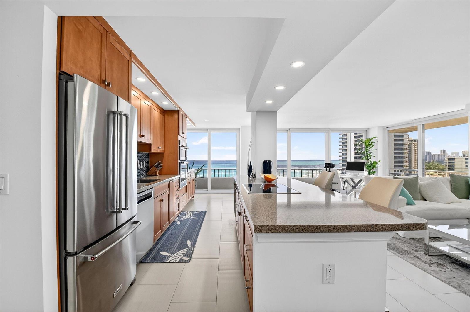 A kitchen with wood cabinets, granite countertops, and a stainless steel refrigerator overlooks the ocean — 5540 N Ocean Drive # 9b, Singer Island FL 33404, SINGER ISLAND, FL