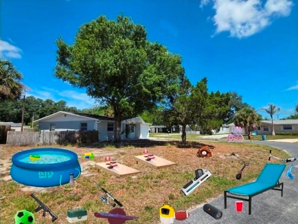 A single-story house with a large tree in the front yard and a wooden fence — 4616 IRENE LOOP, NEW PORT RICHEY, FL