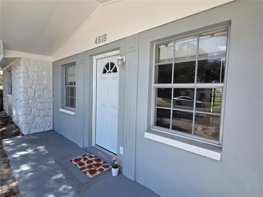 An open-concept living area features light gray walls, white tile flooring, and a ceiling fan — 4616 IRENE LOOP, NEW PORT RICHEY, FL