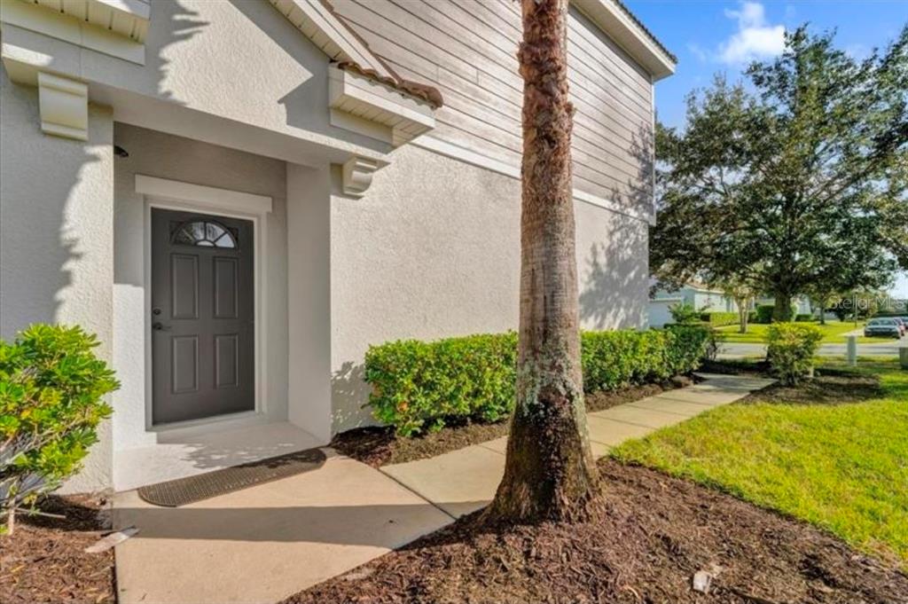 A living room features a leather sofa, two armchairs, a coffee table, and wall shelving — 9301 WATCHET WAY, ORLANDO, FL
