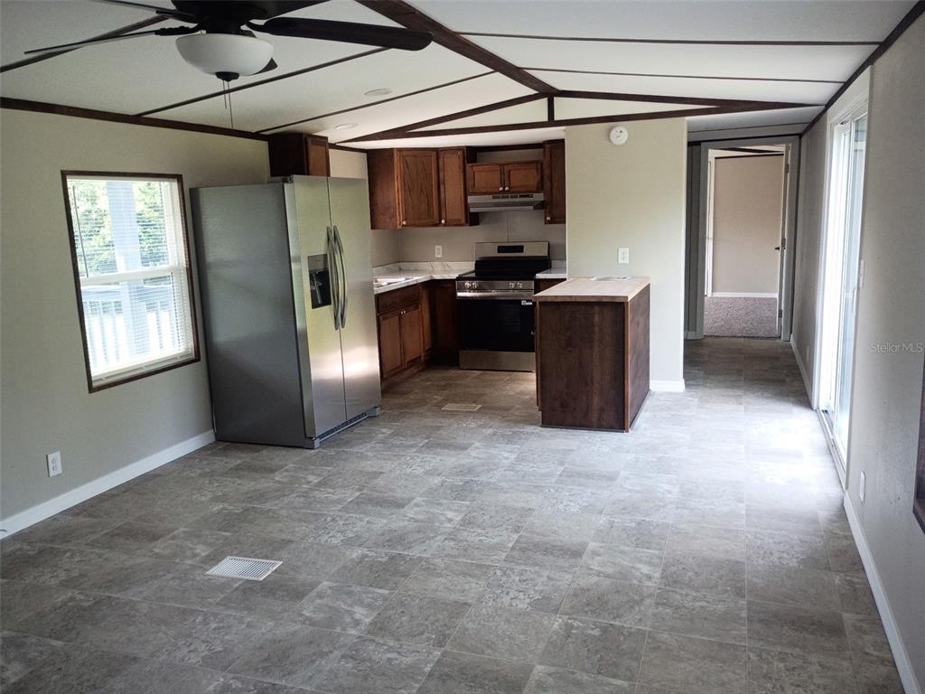 A kitchen with stainless steel appliances, wood cabinets, and gray tile flooring — 11441 KO DRIVE, LAKELAND, FL