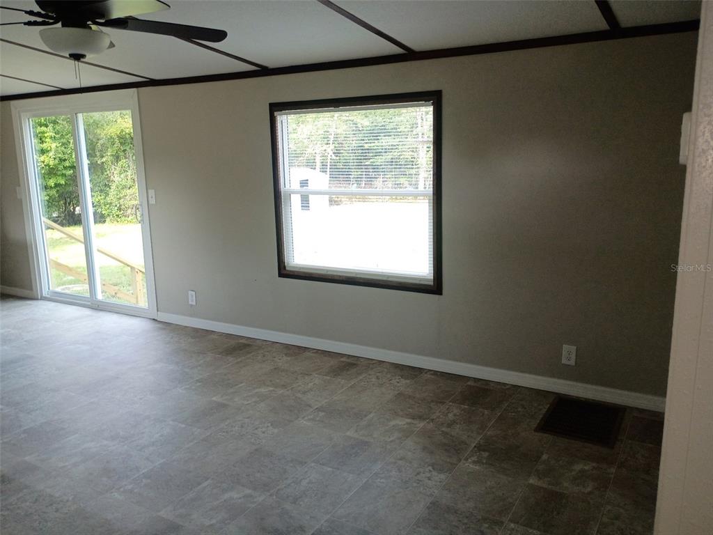 A room with tile flooring, a ceiling fan, a sliding glass door, and a window — 11441 KO DRIVE, LAKELAND, FL