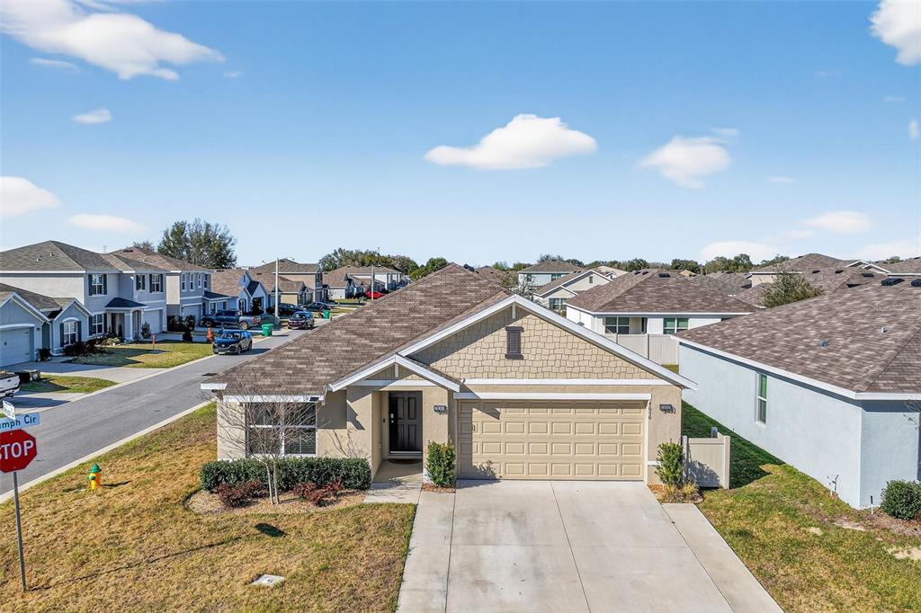An exterior view of a single-story suburban house with a concrete driveway and garage — 4656 CROSSROADS LANE, WILDWOOD, FL